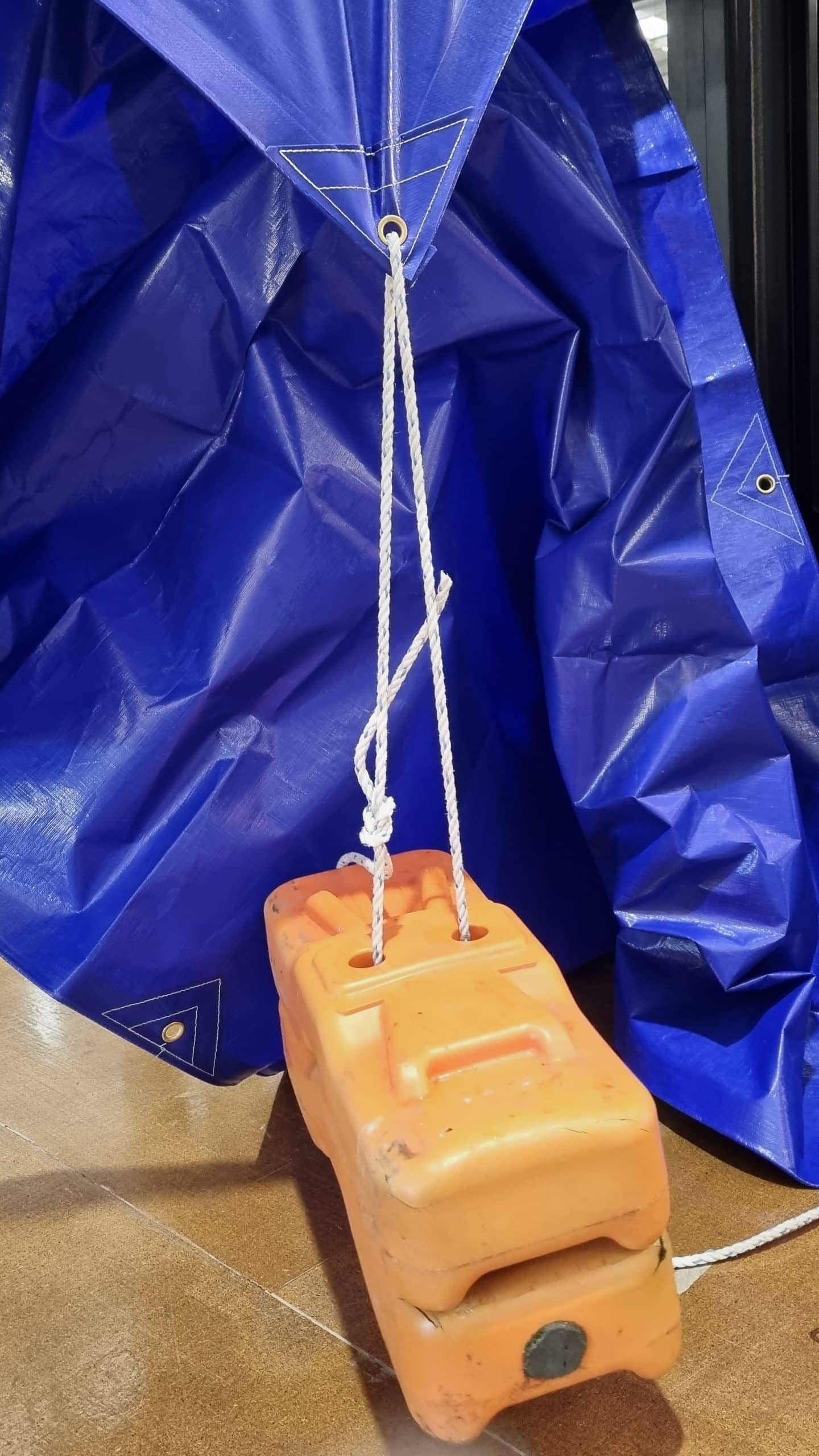 Heavy-duty PE tarp eyelet with rope under tension demonstrating strength