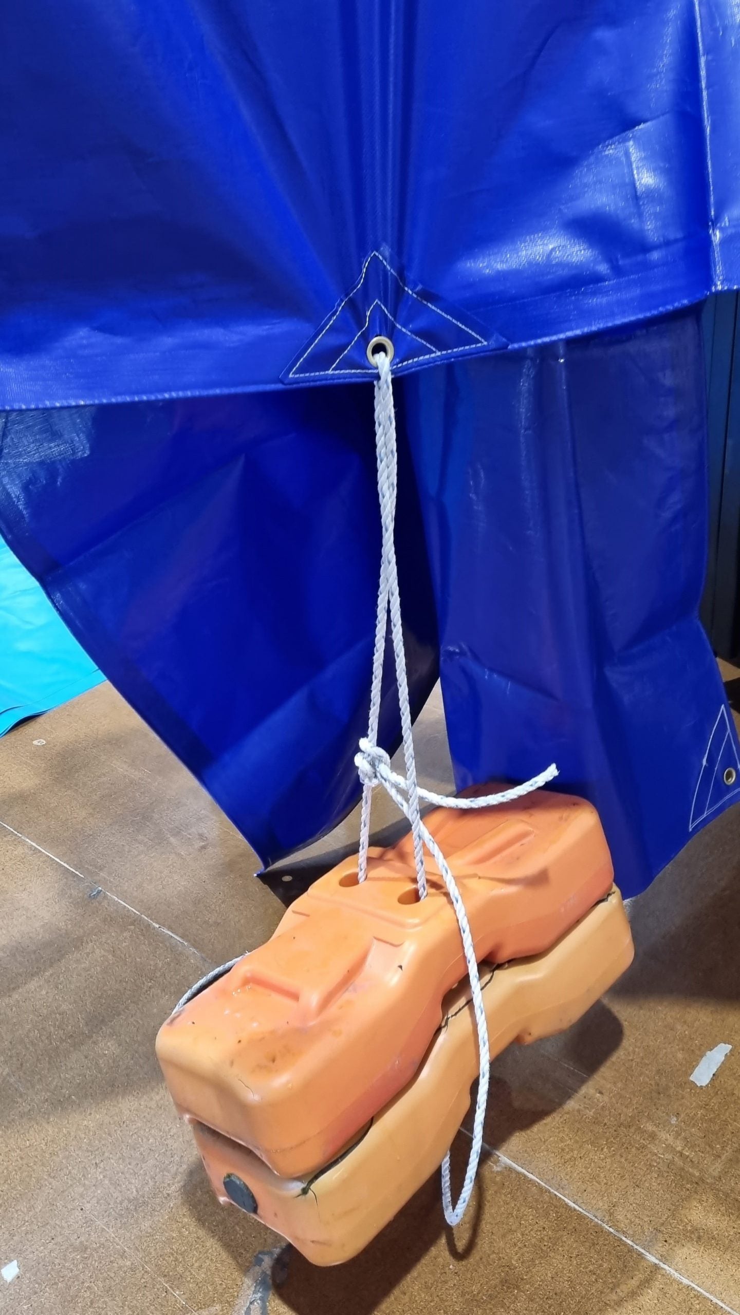 Reinforced brass eyelet with rope pulling tight on heavy-duty PE tarp