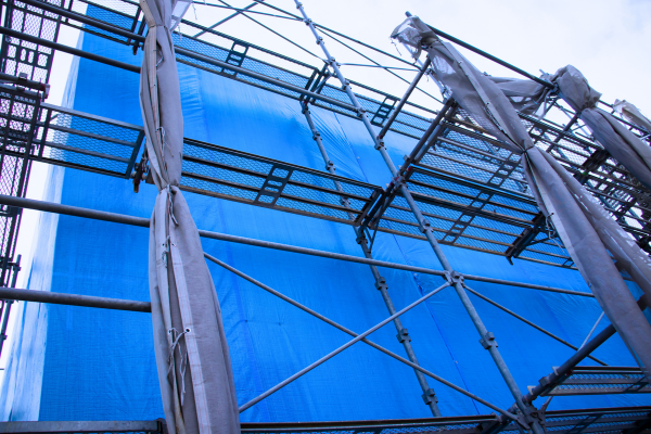 Extra heavy-duty tarp used on construction site to shield building side