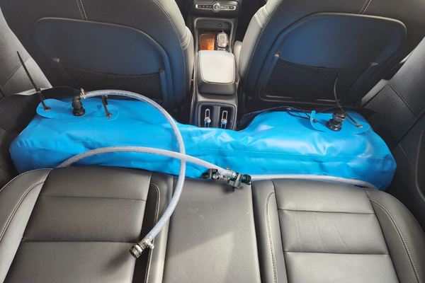 Installed view of the driver-side rear footwell, showing two cutout already fitted with black PVC protective sheet. 
